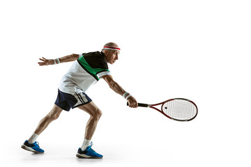 Senior man wearing sportwear playing tennis isolated on white background. Caucasian male model in great shape stays active and sportive. Concept of sport, activity, movement, wellbeing. Copyspace, ad.