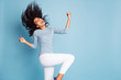 Photo of excited ecstatic overjoyed grimacing girlfriend throwing her hair by waving head in white pants blue sweater rejoicing isolated pastel color background