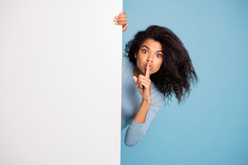 photo of casual curly wavy beautiful brown haired girl showing you shh sign with forefinger touching