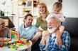 © NDABCREATIVITY - Senior grandparents playing with grandchildren and having fun with family