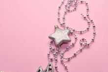 Shiny Silver Christmas Decoration Beads And Star On The Pink Paper Background Closeup Top View Macro. Sparkling Beautiful Background With Free Copy Space Place For Text