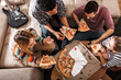 © BalanceFormCreative - Group of friends making fun at the home party.They sitting in living room and eating pizza.