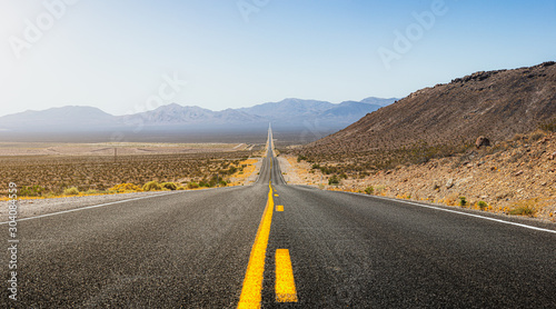 Cuadros en Lienzo Beautiful panoramic view of a long straight road cutting through a barren scener
