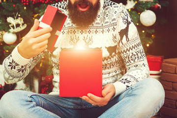 Wall Mural - Emotional guy opened magically Christmas gift at home. Merry Christmas. Happy New Year. Winter holidays, celebration concept