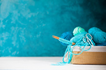 Blue And Aquamarin Yarn For Knitting In A Basket. Knitting Needles, Tape Measure, Glasses.