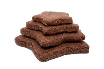 Delicious homemade chocolate and sugar cookies in the shape of stars of different sizes, piled up on top of each other, isolated on a white background. Christmas baking for the whole family