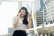© Vee Tanaphot - Close up portrait of a professional business woman smiling calling smartphone urban city downtown