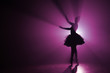 © kohanova1991 - Silhouette of fairy girl dancing ballet in tutu on stage in front of spotlight with colored pink neon light. Copy space. Volumetric painting, smoke scene.