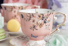 Pink Tea Cups With Floral Ornament And Macaroon Sweets
