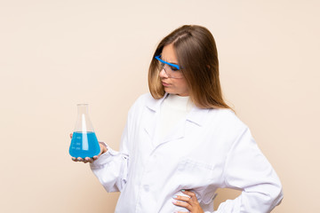 Young blonde woman over isolated background with a scientific test tube