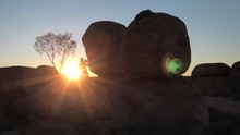 Woman At Evening At Devils Marbles: The Eggs Of Mythical Rainbow Serpent At Karlu Karlu - Devils Marbles Conservation Reserve. Australian Outback Landscape In Northern Territory, Red Centre, Australia