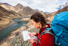A Woman Points At A Location Shown On A Map At Hells Canyon In Idaho While On A Weekend Backpacking Trip[ From Pittsburg Landing To Kirkwood Ranch The Snake River National Recreation Trail #102.
