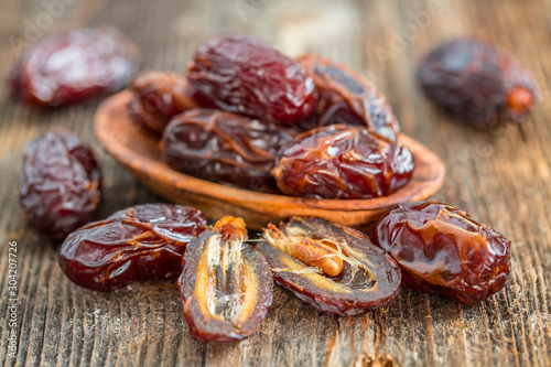 Cuadros en Lienzo Juicy dates in a bowl on a old wooden table .