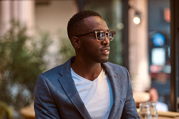 Wall Mural - Portrait of young confident american businessman in sunglasses and blue blazer.