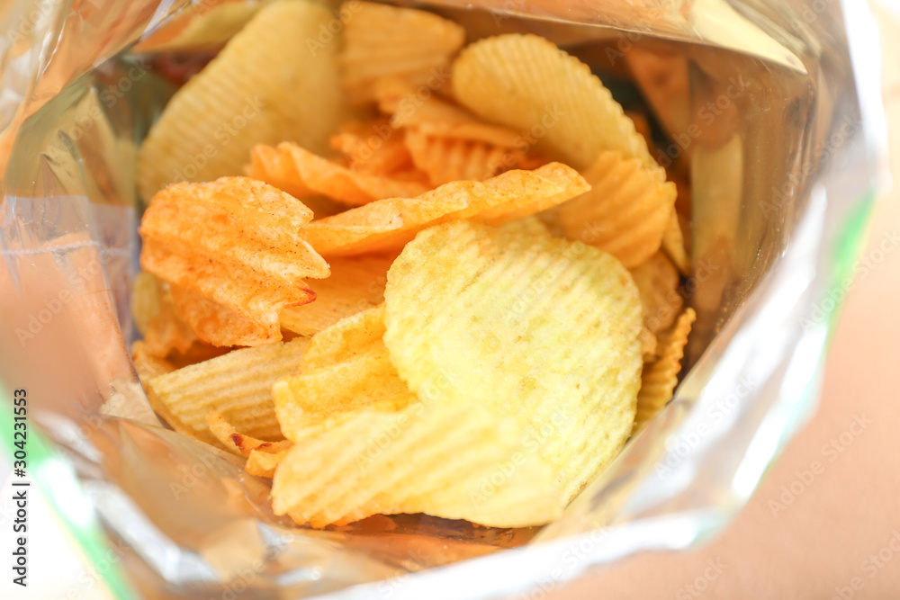 Open pack of tasty potato chips, closeup