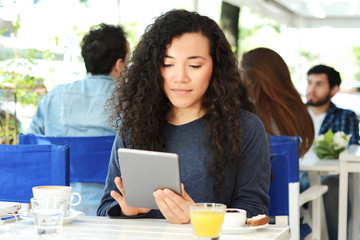Young woman with tablet in coffee shop.