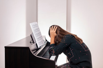 Wall Mural - Girl playing the piano, she has trouble playing piano,