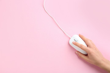 woman using modern wired optical mouse on pink background, top view. space for text