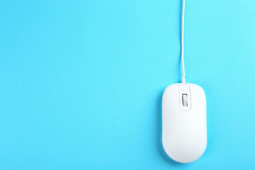 Modern wired mouse on light blue background, top view. Space for text