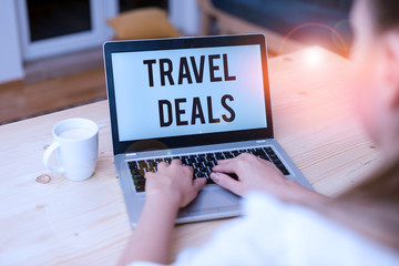 Writing note showing Travel Deals. Business concept for holiday organized by a travel company and pay fixed price woman with laptop smartphone and office supplies technology