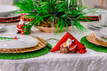 Table served for Christmas dinner with decorations in living room, close up view