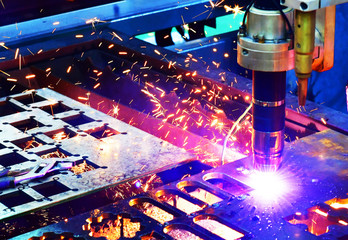 Wall Mural - industrial laser cut machine while cutting the sheet metal with the sparking light.