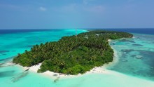 Lush Vegetation And Palm Trees Forest Covering Low Tropical Island With White Beach, Surrounded By Tranquil Lagoon With Beautiful Coral Reef In Pacific Ocean
