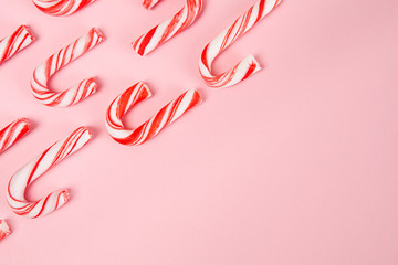 Candy canes pattern on pink background - top view with copy space