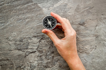 Wall Mural - Choose direction concept. Compass in hand on grey background top view copy space