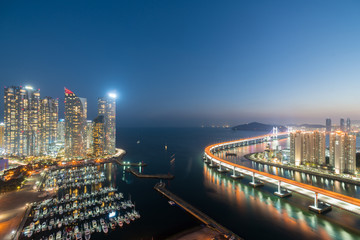 Wall Mural - Busan city skyline in Haeundae business district area skyline view from roof top at night in Busan ,South Korea. Asian tourism, modern city life, or business finance and economy concept.