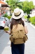 © i am way - Asian woman with backpack and drink coconut travel walking in street in city