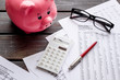 © 9dreamstudio - Taxes payment concept. Financial documents, piggy bank, calculator on dark wooden background