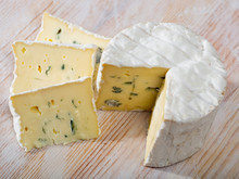 Slices Of Tasty Soft Blue Cheese With Blue Mold At Wooden Board