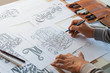 Typography Calligraphy artist designer drawing sketch writes letting spelled pen brush ink paper table artwork.Workplace design studio.
