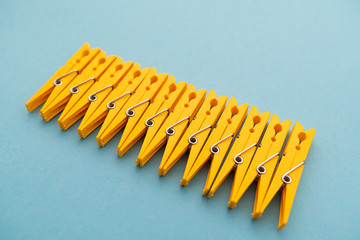 yellow plastic clothespins on blue background