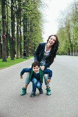 Wall Mural - Cute little son on a piggy back ride with his mother. Looking at camera.