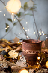 Mug of tea in autumn foliage