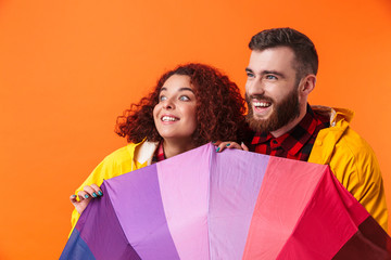 Canvas Print - Loving couple posing in yellow raincoats isolated