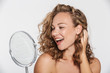 © Drobot Dean - Image of excited half-naked woman smiling and looking at mirror