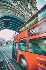 Red bus crossing Tower Birdge on a beautiful afternoon, London