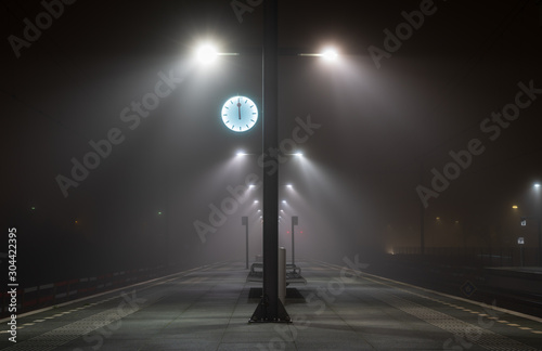 Fotografía Illuminated, empty platform at a railroad station during a foggy night in autumn