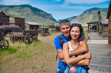 Poster - Happy couple embracing while visiting old west town in USA. Holiday concept