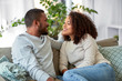 © Syda Productions - relationships, communication and people concept - happy african american couple sitting on sofa and talking at home