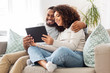 © Syda Productions - technology, internet and people concept - happy african american couple with tablet computer at home