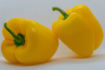  Two yellow peppers on a white background