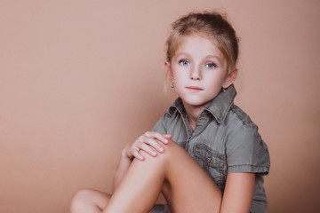 close up portrait of cheerful adorable teen girl posing in studio on brown background. teenage styli