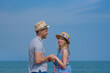 © Artem - Young beautiful European couple standing on pier against amazing blue sea, they holding hands and enjoying their holidays.