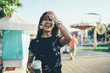 Half length portrait of excited teenage woman rejoicing in Amusement park feeling amazing mood from recreation day outside, happy Asian woman with coffee to go laughing and posing near bubbles