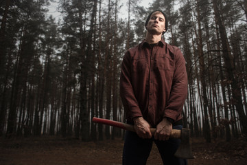 Wall Mural - Strong lumberjack with the ax in the forest.Stylish lumberman getting ready for work. Lifestyle.