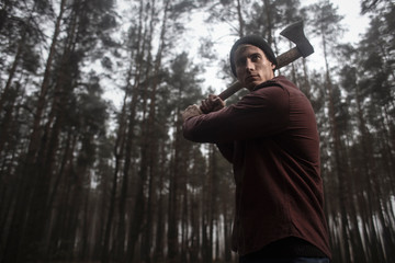 Wall Mural -  Lumberjack with the ax in the forest.Stylish lumberman getting ready for work. Hard iwork in the forest. Lumberjack chopping a tree. Lifestyle. 